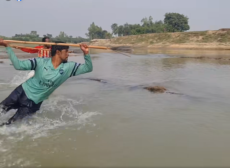 a man holding a broom in a river